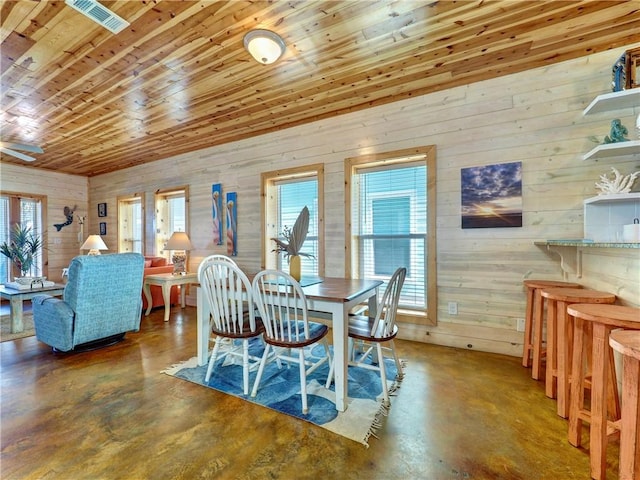 dining space with concrete floors and wood ceiling