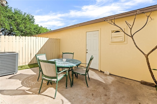 view of patio / terrace with outdoor dining space, central AC, and fence