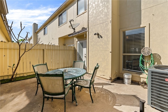 view of patio / terrace featuring fence, outdoor dining area, and cooling unit