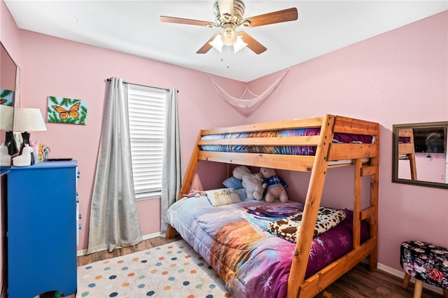 bedroom with ceiling fan, baseboards, and wood finished floors