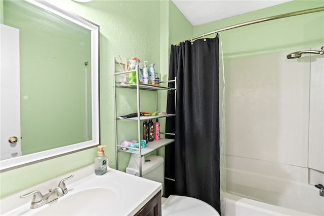 full bath with shower / tub combo, a textured wall, vanity, and toilet