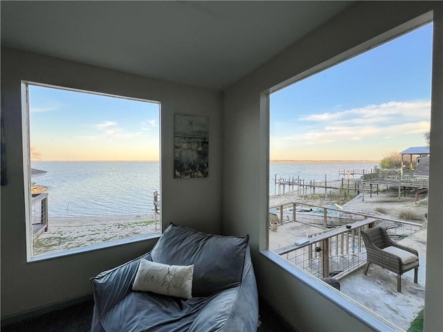 balcony at dusk with a water view and a beach view