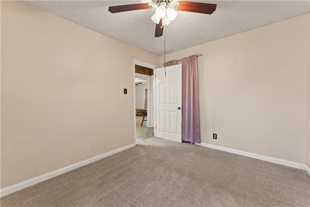 carpeted empty room featuring ceiling fan and a textured ceiling