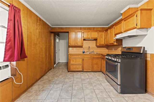 kitchen featuring light tile patterned flooring, sink, ornamental molding, and stainless steel gas range