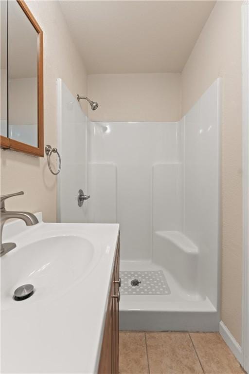 bathroom featuring tile patterned floors, vanity, and a shower