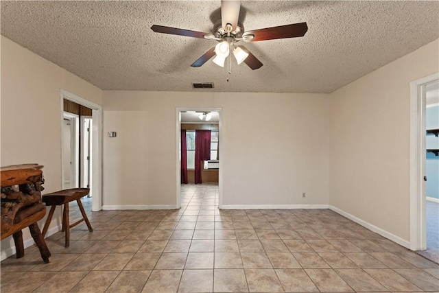 tiled empty room with ceiling fan and a textured ceiling