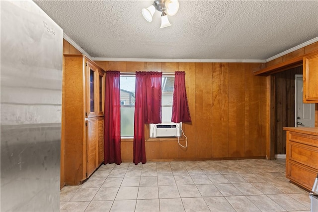 empty room featuring a textured ceiling, cooling unit, crown molding, and wooden walls