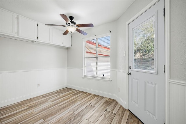 doorway with ceiling fan and light wood-type flooring