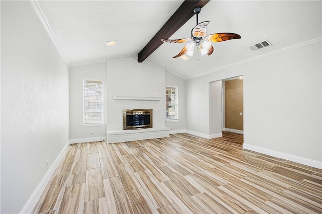 unfurnished living room featuring lofted ceiling with beams, a healthy amount of sunlight, a fireplace, and light wood-type flooring