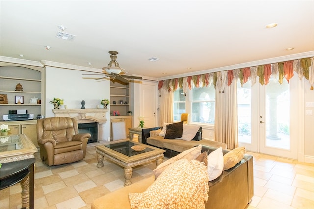 living room featuring french doors, ceiling fan, built in features, and crown molding