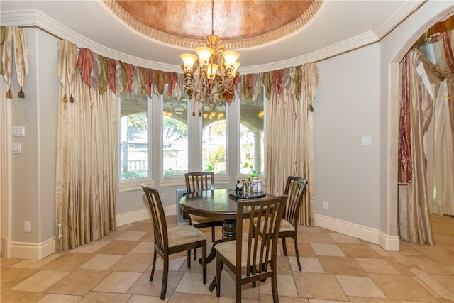 dining area featuring an inviting chandelier, crown molding, and a tray ceiling