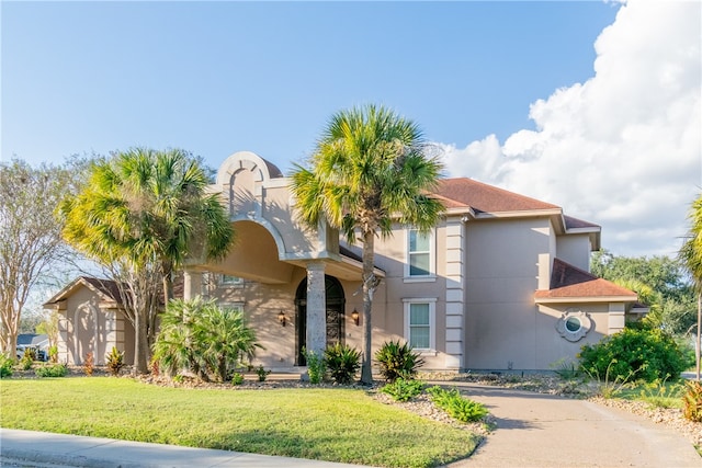 mediterranean / spanish home featuring a front lawn