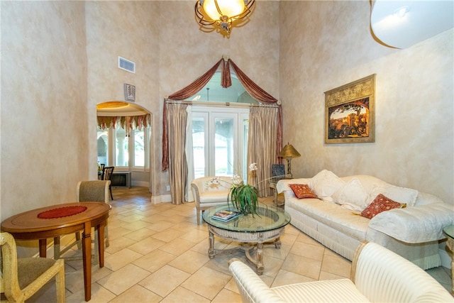 living room with a towering ceiling and light tile patterned flooring