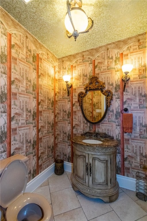 bathroom with toilet, vanity, and tile patterned floors