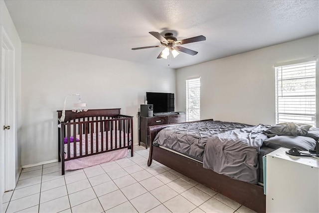 tiled bedroom featuring a textured ceiling and ceiling fan