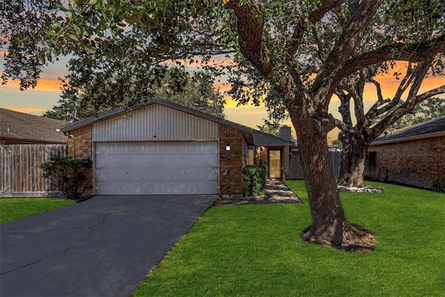 single story home featuring a yard and a garage