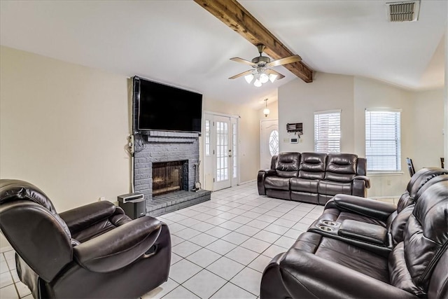 living room with vaulted ceiling with beams, a brick fireplace, ceiling fan, and light tile patterned floors