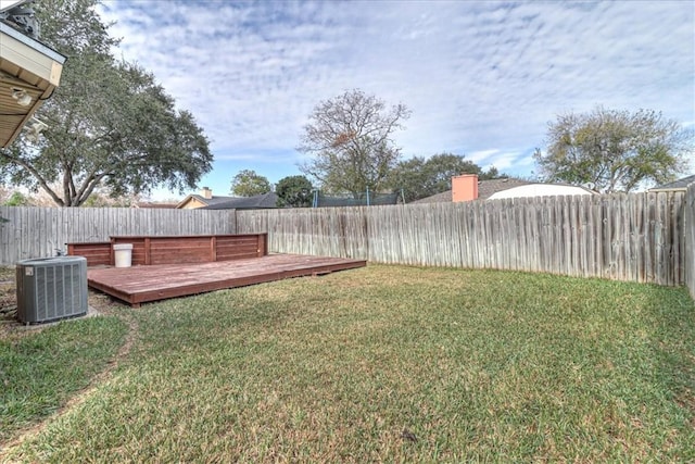 view of yard with central AC and a deck