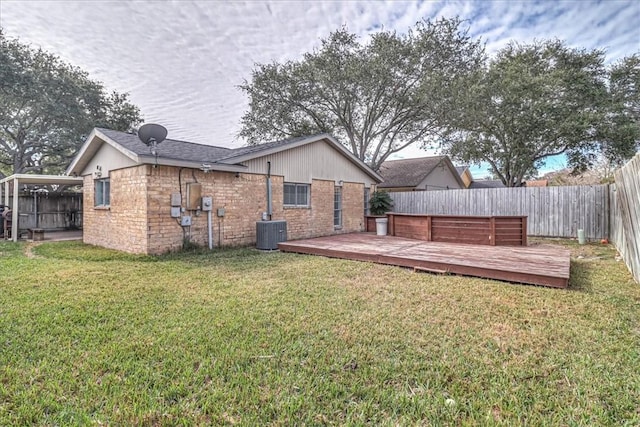 rear view of property with central air condition unit, a deck, and a lawn