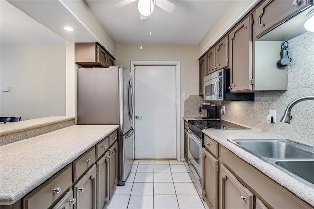 kitchen featuring backsplash, stainless steel appliances, ceiling fan, sink, and light tile patterned flooring