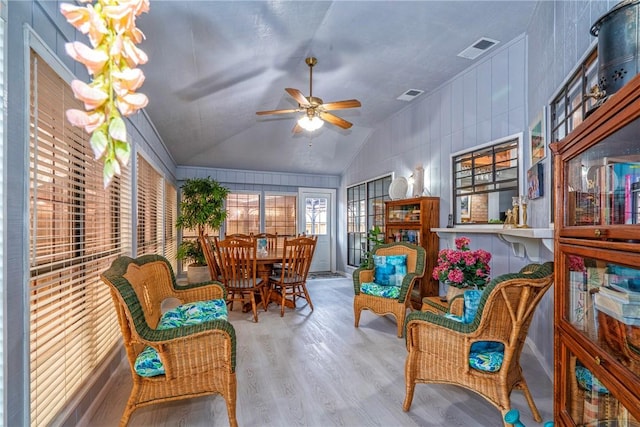 sunroom / solarium featuring lofted ceiling, visible vents, and a ceiling fan