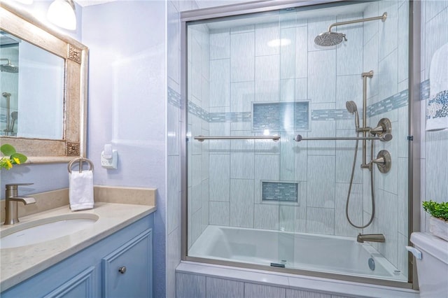 bathroom featuring enclosed tub / shower combo, vanity, and toilet