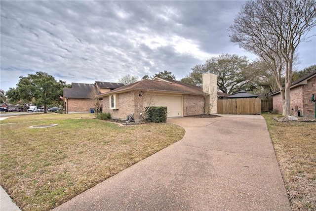 view of front of property with brick siding, concrete driveway, an attached garage, fence, and a front lawn