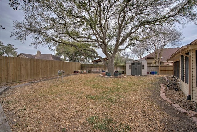 view of yard with a shed, an outdoor structure, and a fenced backyard