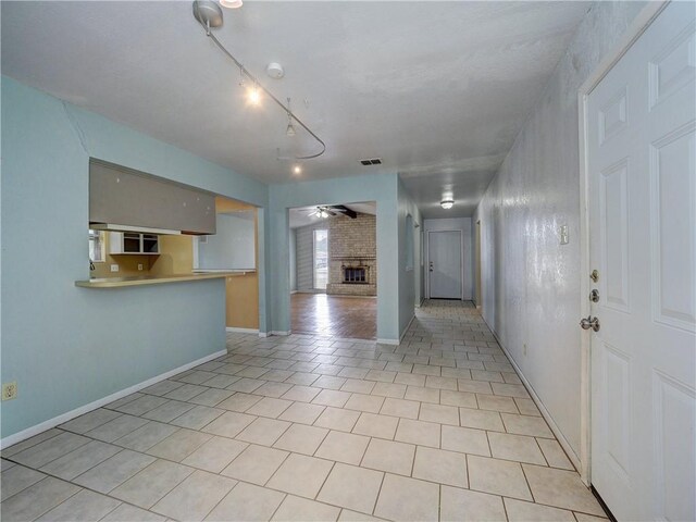 2100 Memorial Pkwy, Portland, TX 78374 - kitchen with light tile patterned floors, a brick fireplace, a ceiling fan, baseboards, and open floor plan