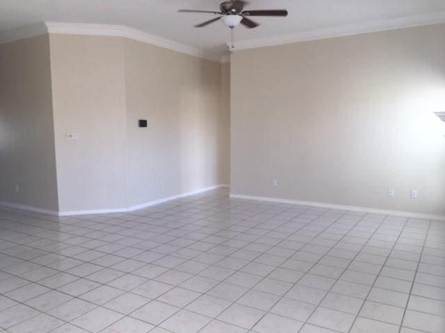 spare room featuring ceiling fan, baseboards, and crown molding