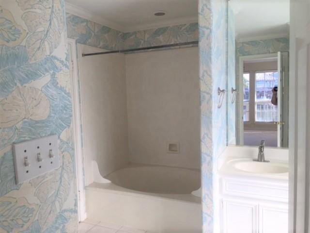 full bathroom featuring wallpapered walls, tile patterned floors, tub / shower combination, crown molding, and vanity