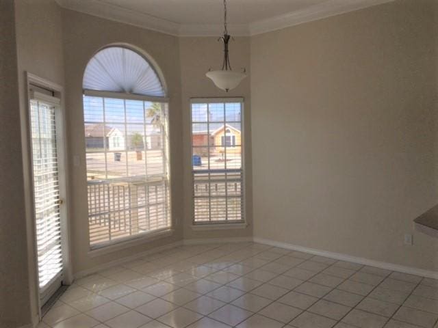 unfurnished dining area featuring light tile patterned floors, baseboards, and crown molding