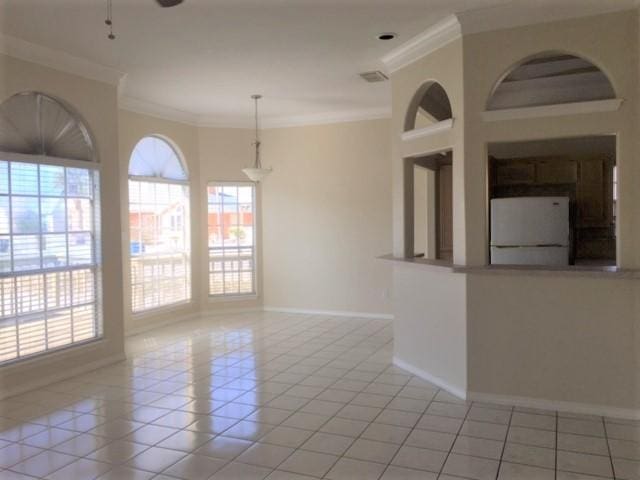 unfurnished room featuring light tile patterned floors, ornamental molding, and baseboards