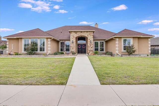 6241 Lago Vista Dr, Corpus Christi, TX 78414 - view of front of house featuring stucco siding, a front yard, and a chimney