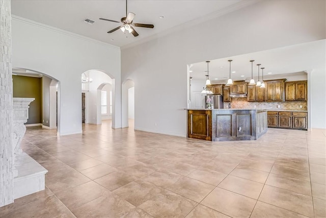 6241 Lago Vista Dr, Corpus Christi, TX 78414 - unfurnished living room with a ceiling fan, ornamental molding, arched walkways, light tile patterned floors, and a high ceiling