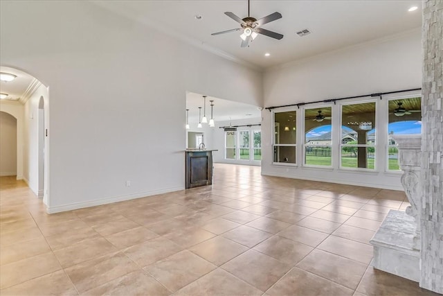 6241 Lago Vista Dr, Corpus Christi, TX 78414 - unfurnished living room with crown molding, a ceiling fan, arched walkways, light tile patterned floors, and a towering ceiling