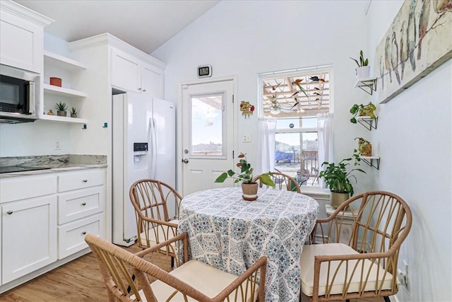 dining room with lofted ceiling and light wood-style floors