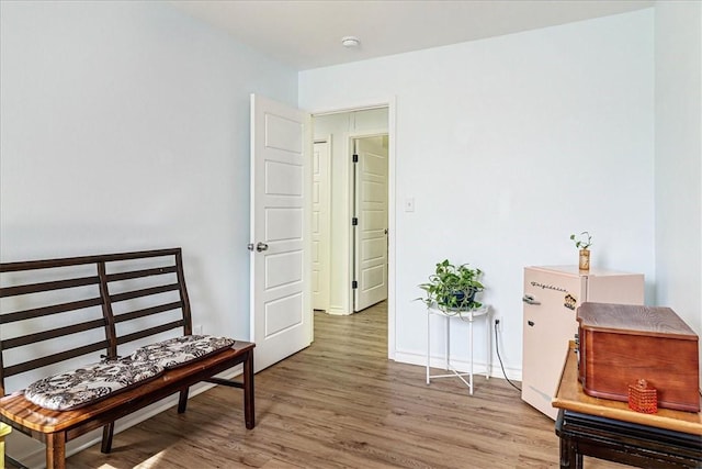 sitting room with baseboards and wood finished floors