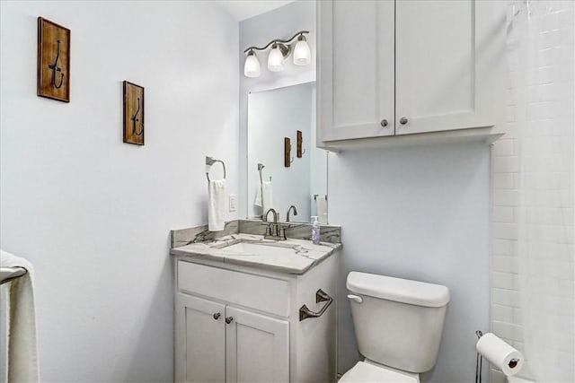 bathroom featuring a shower, toilet, and vanity