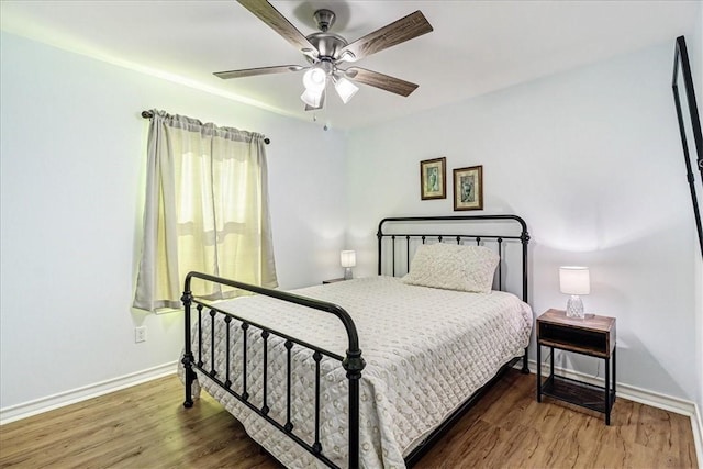 bedroom featuring a ceiling fan, wood finished floors, and baseboards