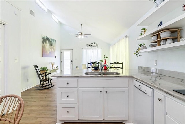 kitchen featuring dishwasher, a peninsula, white cabinets, and a sink