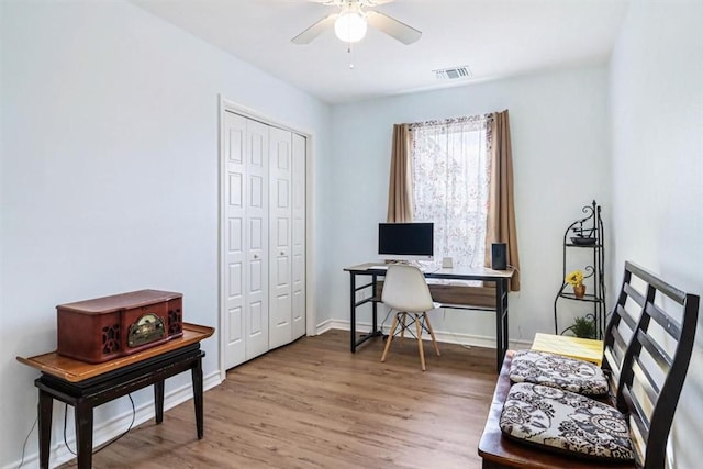 office space with visible vents, wood finished floors, baseboards, and ceiling fan