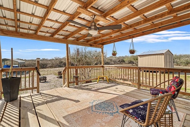 wooden terrace with an outbuilding, a storage unit, and a ceiling fan