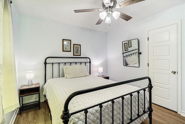 bedroom featuring a ceiling fan, baseboards, and light wood finished floors