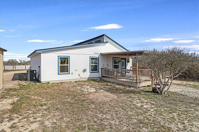 back of house with central AC unit and stucco siding