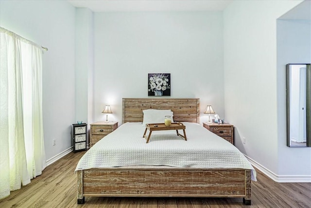 bedroom featuring baseboards and wood finished floors