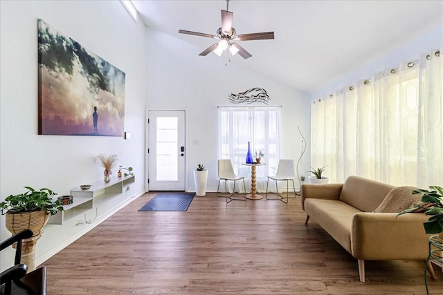 living area featuring high vaulted ceiling, baseboards, a ceiling fan, and wood finished floors