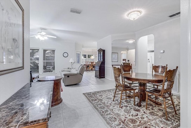 tiled dining room featuring crown molding and ceiling fan