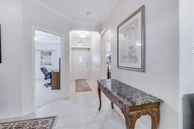 entryway with ornamental molding and light tile patterned floors