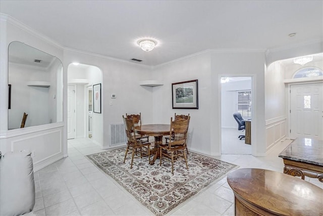 tiled dining room featuring ornamental molding